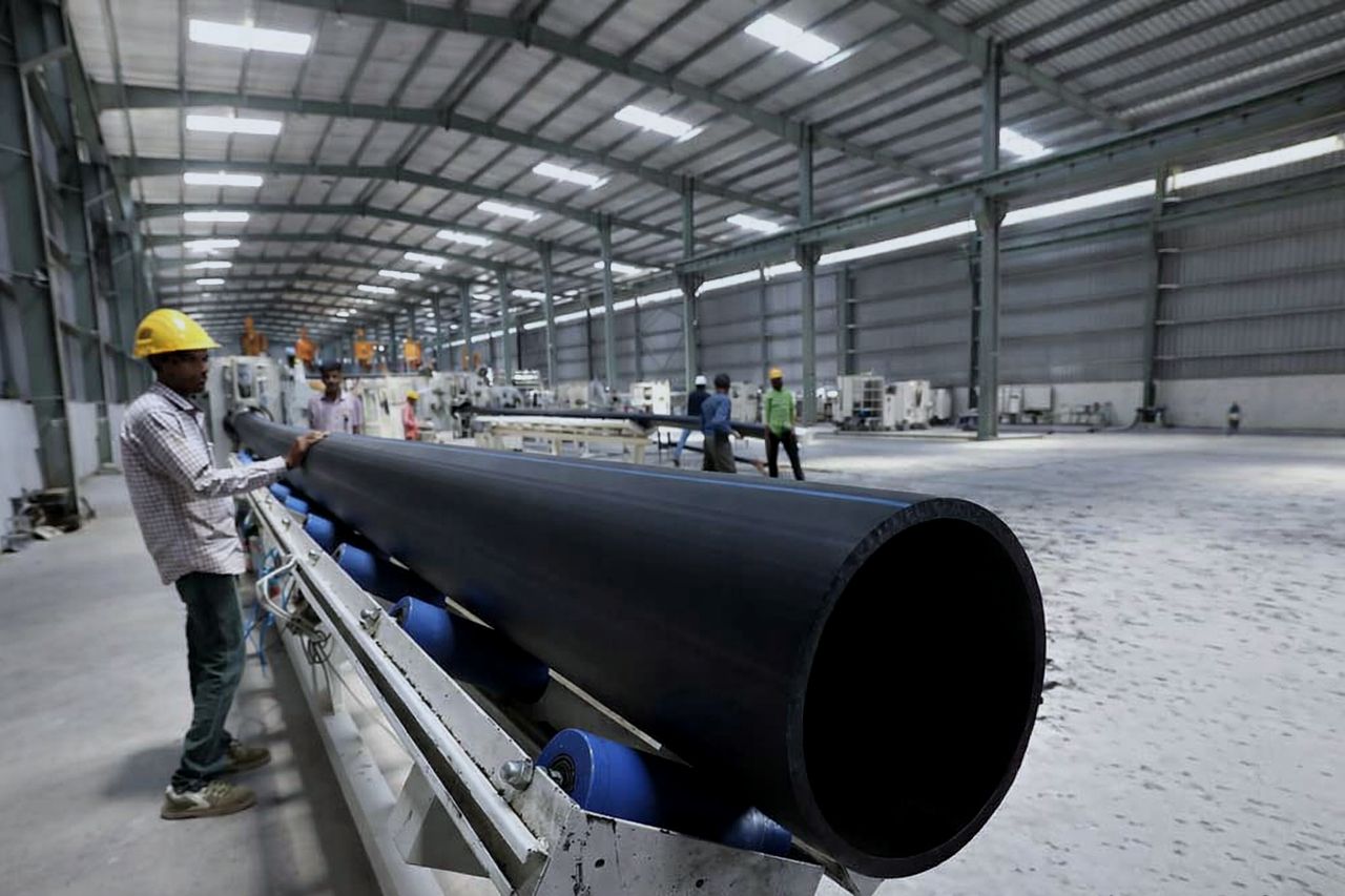Operator handling large-diameter HDPE pipe on the production line inside the Maruti Pipes plant