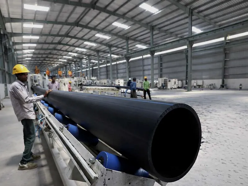 Operator handling large-diameter HDPE pipe on the Maruti Pipes production line